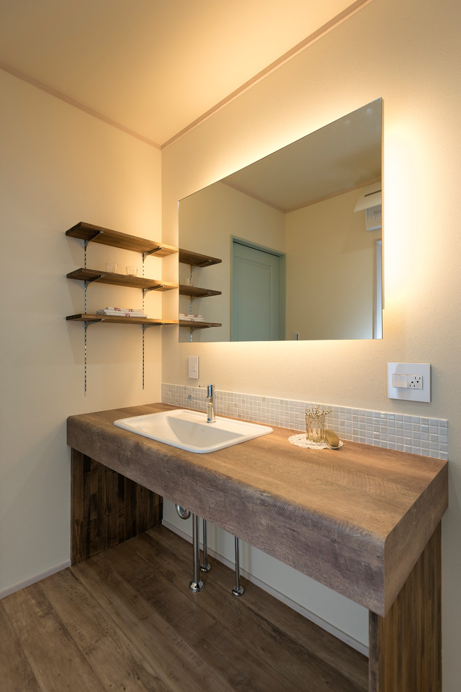 名古屋にあるアジアンスタイルのおしゃれなトイレ・洗面所 (オープンシェルフ、白い壁、無垢フローリング、オーバーカウンターシンク、木製洗面台、茶色い床、ブラウンの洗面カウンター) の写真