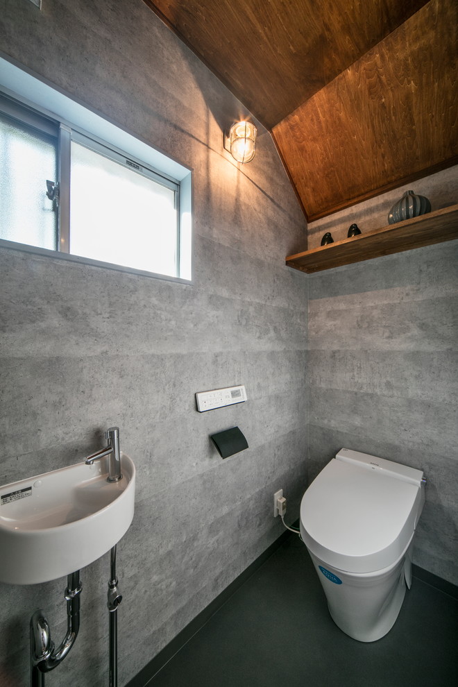 Идея дизайна: туалет в современном стиле с открытыми фасадами, фасадами цвета дерева среднего тона, серыми стенами, серым полом и подвесной раковиной