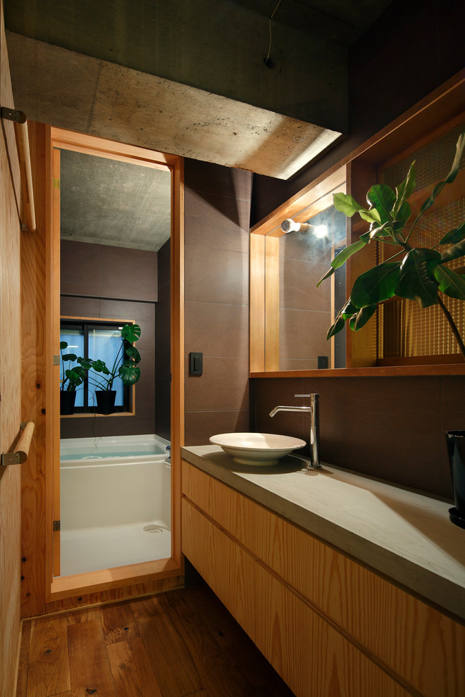 東京23区にあるミッドセンチュリースタイルのおしゃれなトイレ・洗面所 (フラットパネル扉のキャビネット、中間色木目調キャビネット、茶色い壁、無垢フローリング、ベッセル式洗面器、茶色い床) の写真