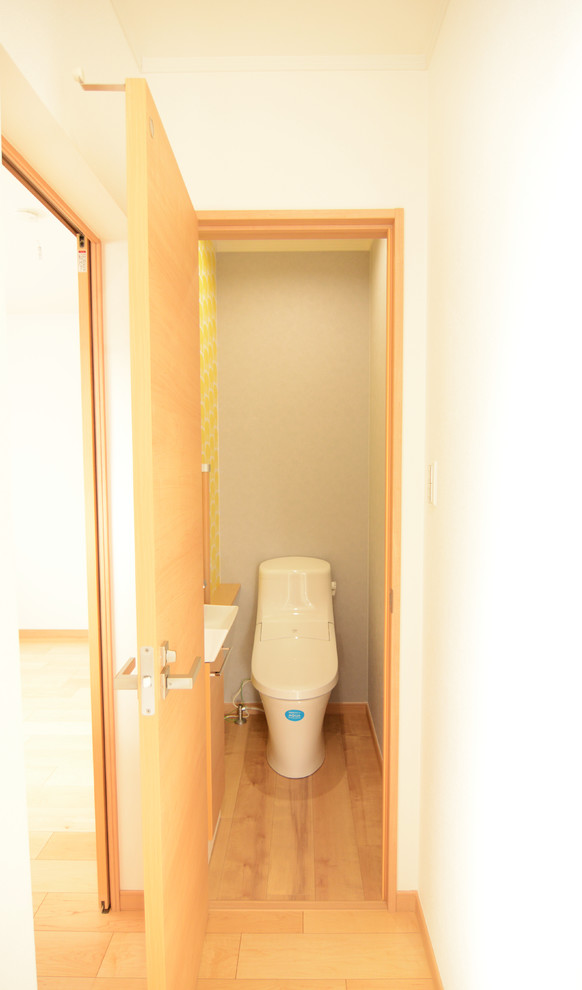 Gästetoilette mit beigen Schränken, Toilette mit Aufsatzspülkasten, Vinylboden und beigem Boden in Sonstige