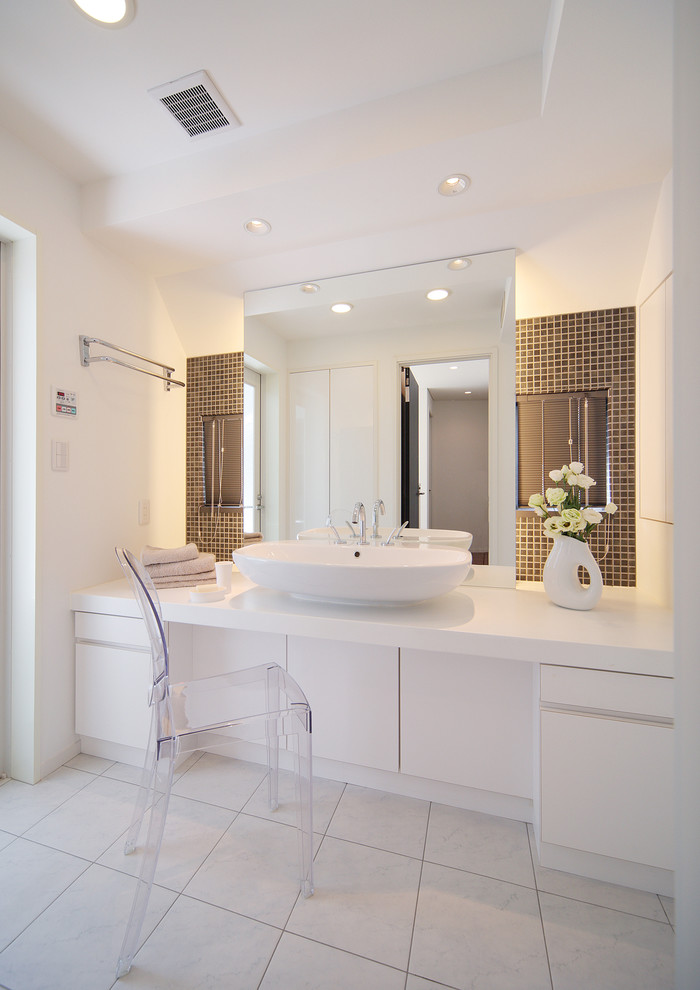 Aménagement d'un grand WC et toilettes contemporain avec un placard à porte plane, des portes de placard blanches, un carrelage marron, mosaïque, un mur blanc, un sol en carrelage de porcelaine, un plan vasque et un sol blanc.
