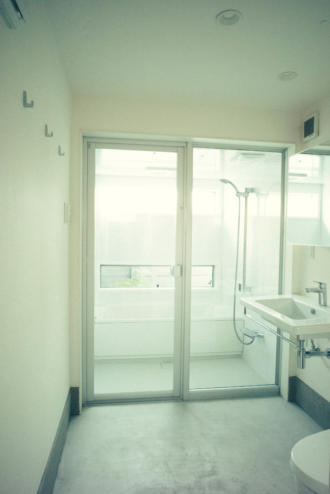 Exemple d'un WC et toilettes moderne de taille moyenne avec un placard à porte plane, des portes de placard blanches, un mur blanc, un sol en bois brun, un lavabo suspendu et WC à poser.