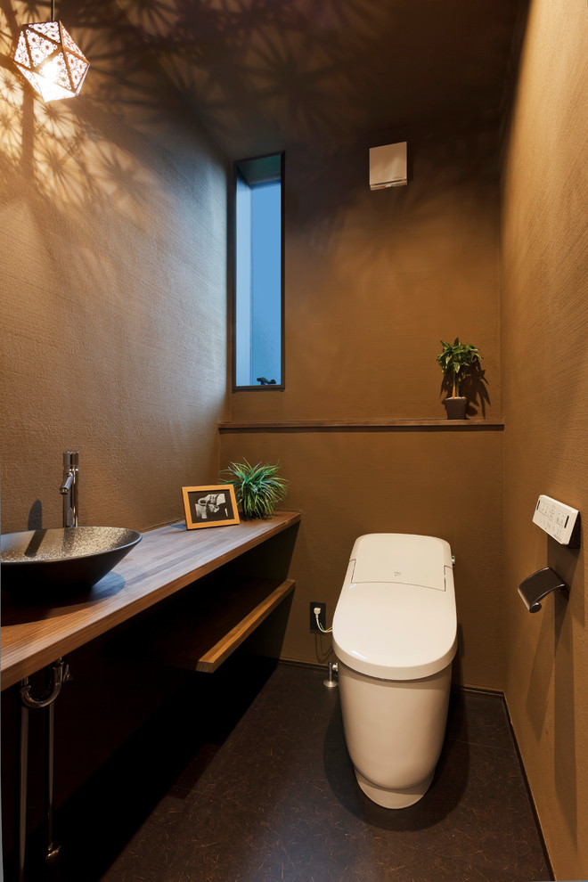 他の地域にあるミッドセンチュリースタイルのおしゃれなトイレ・洗面所 (一体型トイレ	、ベージュの壁、茶色い床、ブラウンの洗面カウンター) の写真