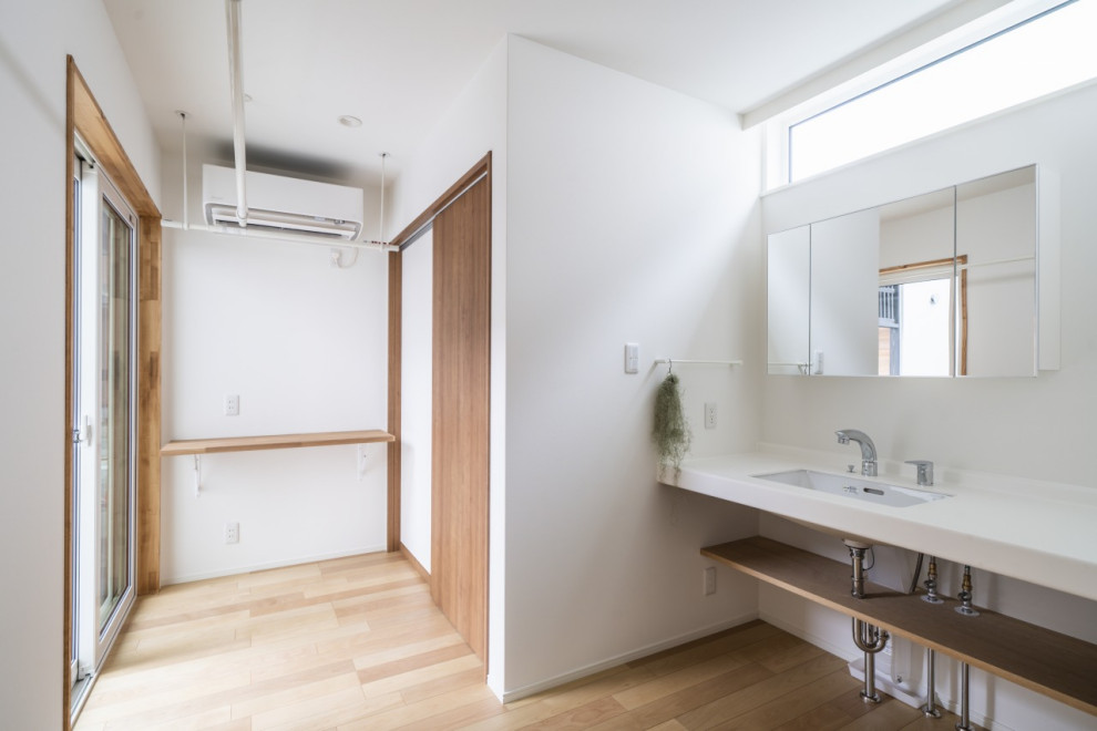 Exemple d'un WC et toilettes moderne de taille moyenne avec un mur blanc, parquet clair, un sol beige, un plafond en papier peint et du papier peint.