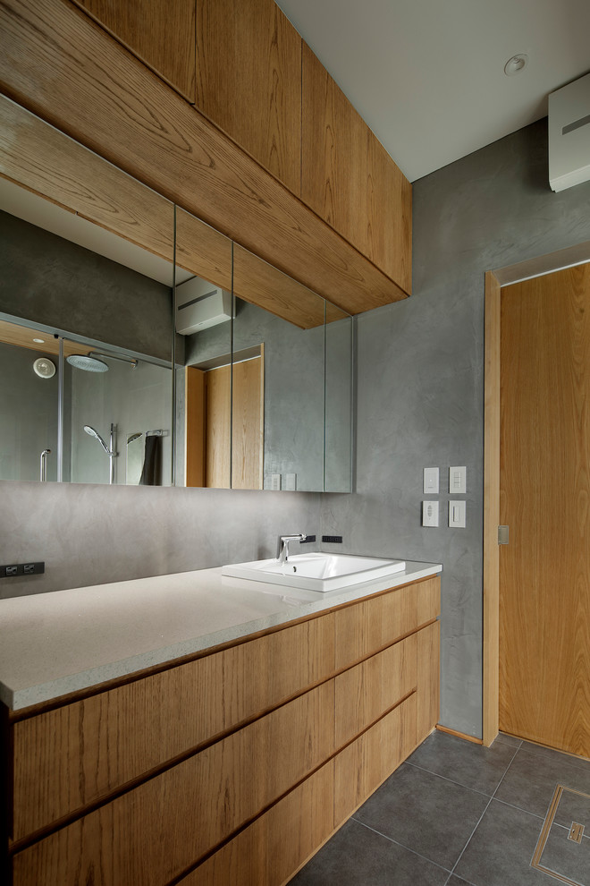 Cette image montre un WC et toilettes minimaliste en bois brun de taille moyenne avec un placard à porte plane, un mur gris, un sol en carrelage de céramique, un lavabo posé, un plan de toilette en quartz modifié, un sol gris et un plan de toilette multicolore.