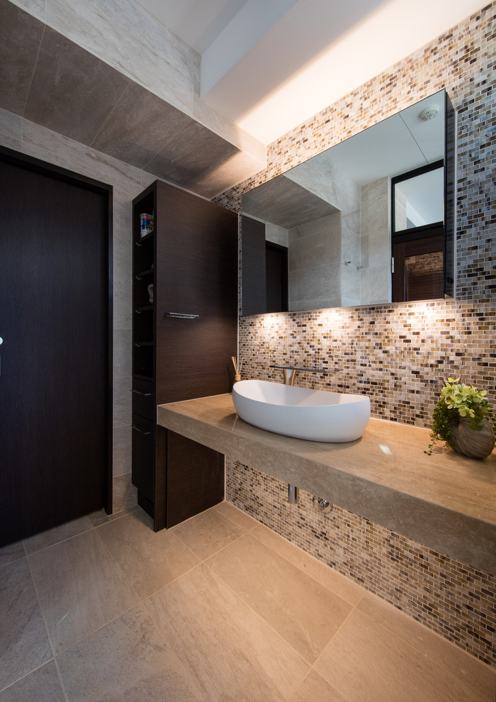 Idée de décoration pour un WC et toilettes design avec un mur gris, une vasque et un sol beige.
