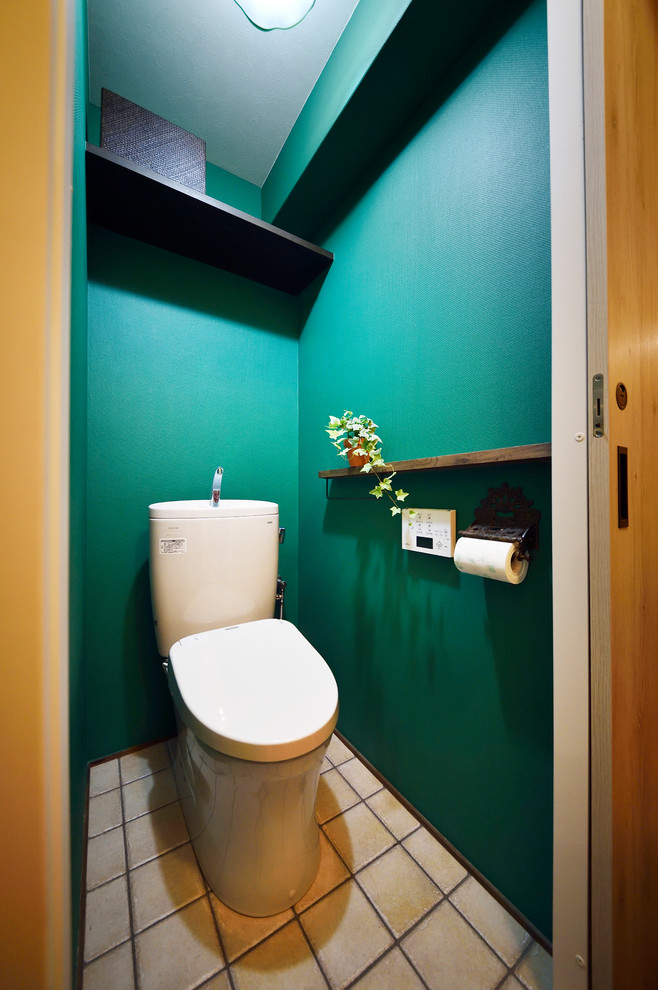 Ejemplo de aseo asiático con paredes verdes, suelo de baldosas de terracota y suelo marrón