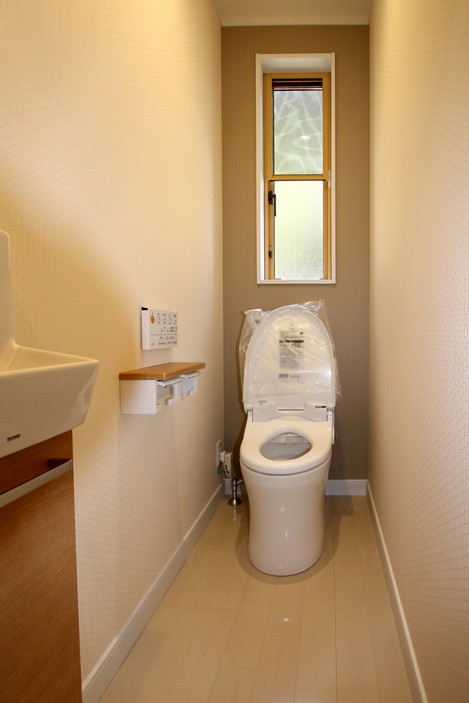 На фото: маленький туалет в стиле модернизм с фасадами цвета дерева среднего тона, унитазом-моноблоком, бежевыми стенами, полом из фанеры и белым полом для на участке и в саду с