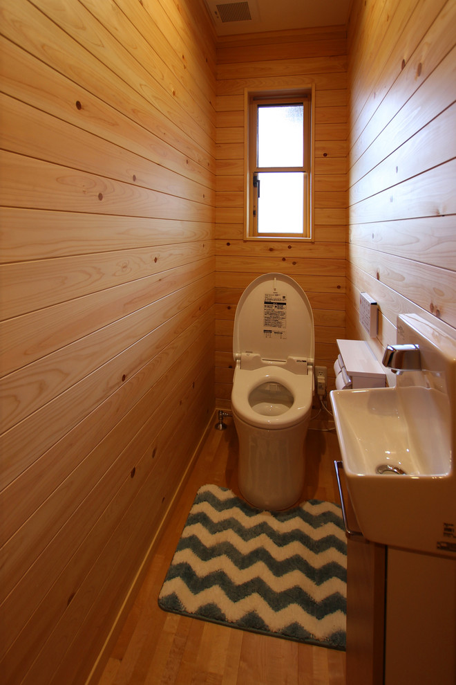 Kleine Landhaus Gästetoilette mit Wandtoilette, beiger Wandfarbe, Sperrholzboden und beigem Boden in Sonstige