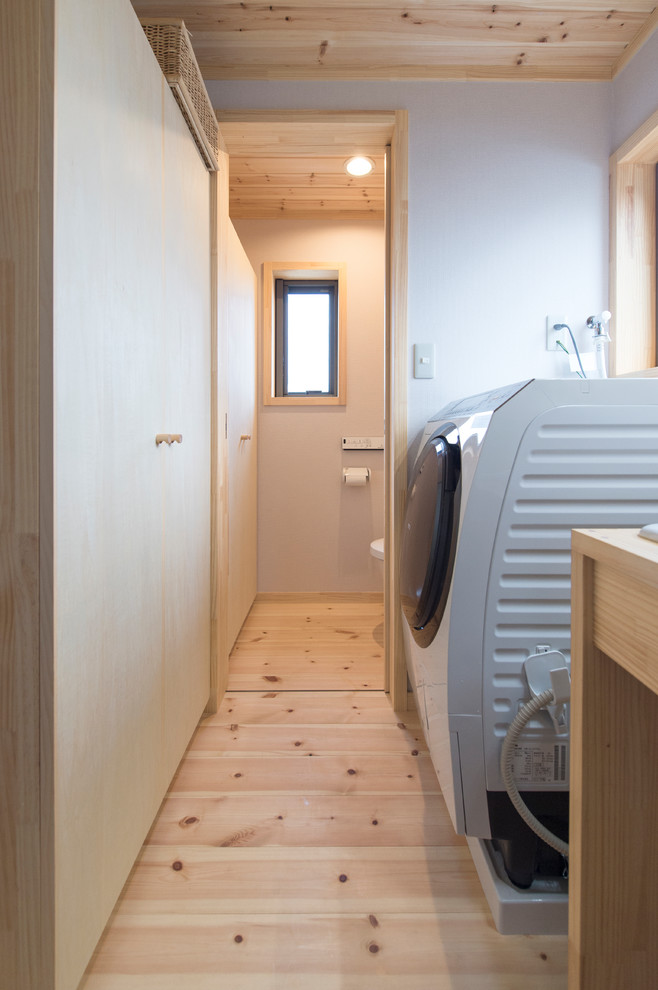 Idee per un bagno di servizio minimalista di medie dimensioni con pavimento in legno massello medio e pavimento bianco