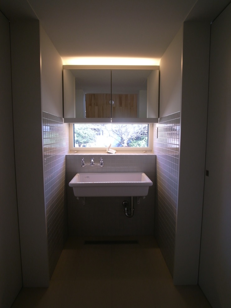 Idéer för ett mellanstort modernt vit toalett, med luckor med profilerade fronter, grå skåp, grå kakel, keramikplattor, vita väggar, klinkergolv i keramik, kaklad bänkskiva och beiget golv