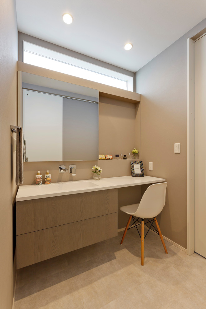 Ispirazione per un bagno di servizio scandinavo con ante lisce, ante grigie, pareti grigie, lavabo integrato, pavimento grigio e top bianco