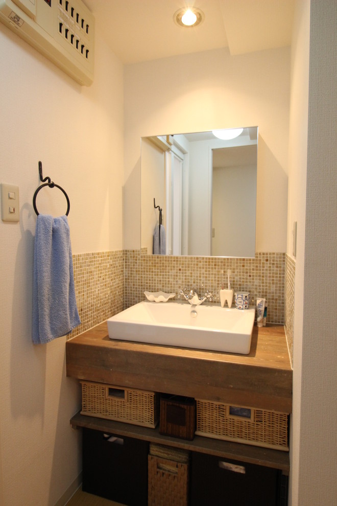 На фото: туалет в скандинавском стиле с коричневой плиткой, стеклянной плиткой и настольной раковиной