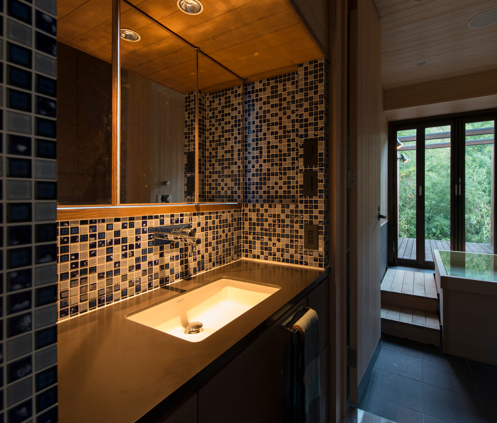 Идея дизайна: туалет в восточном стиле с фасадами с декоративным кантом, синей плиткой, полом из керамической плитки, серым полом и коричневой столешницей