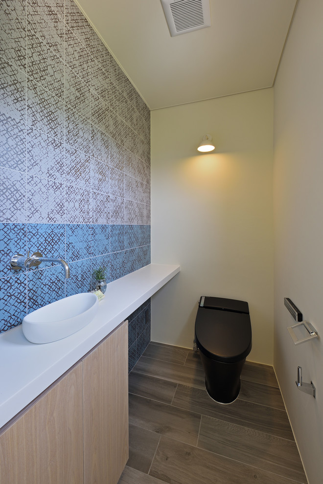 Свежая идея для дизайна: туалет в восточном стиле с плоскими фасадами, коричневыми фасадами, разноцветными стенами, деревянным полом и серым полом - отличное фото интерьера
