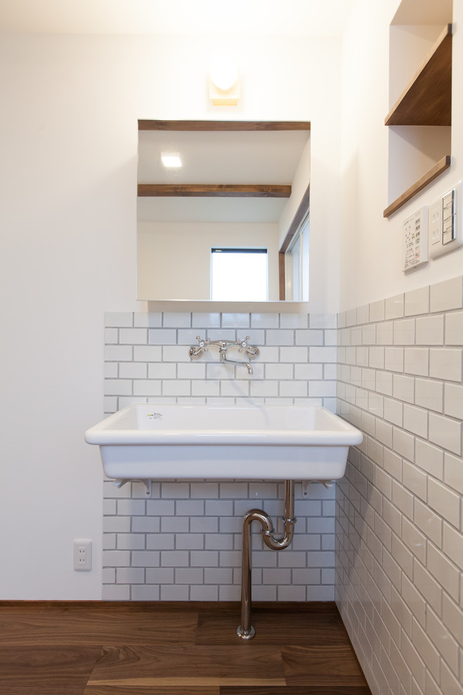 Example of a small asian ceramic tile plywood floor and brown floor powder room design in Other with glass-front cabinets, white cabinets, white walls and white countertops