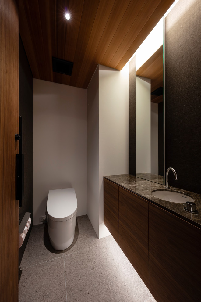 Источник вдохновения для домашнего уюта: туалет в стиле модернизм с плоскими фасадами, темными деревянными фасадами, белыми стенами, монолитной раковиной, мраморной столешницей, серым полом и коричневой столешницей