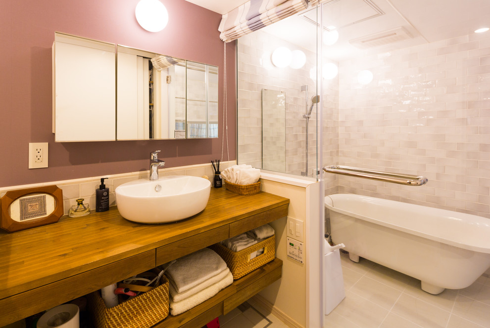 Cette image montre une salle de bain nordique de taille moyenne avec un placard sans porte, WC à poser, un carrelage gris, des carreaux de porcelaine, un mur violet, un sol en carrelage de porcelaine, une vasque, un plan de toilette en bois, un sol blanc et un plan de toilette marron.