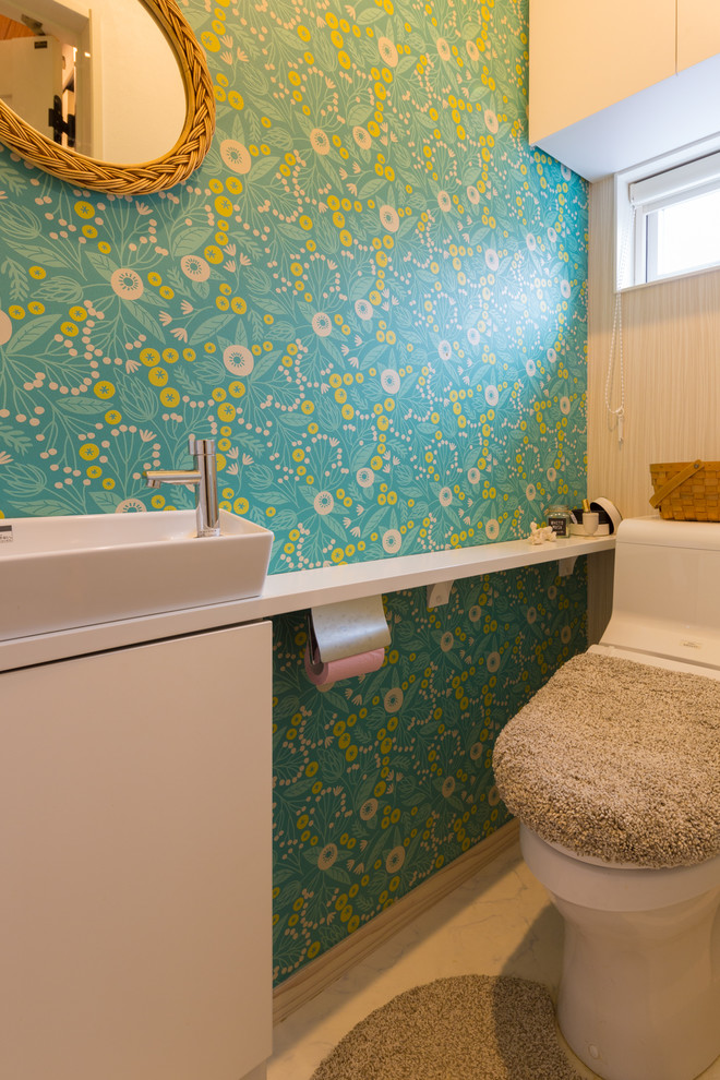 Idéer för att renovera ett mellanstort skandinaviskt vit vitt toalett, med släta luckor, vita skåp, en toalettstol med hel cisternkåpa, gröna väggar, linoleumgolv, ett fristående handfat och vitt golv