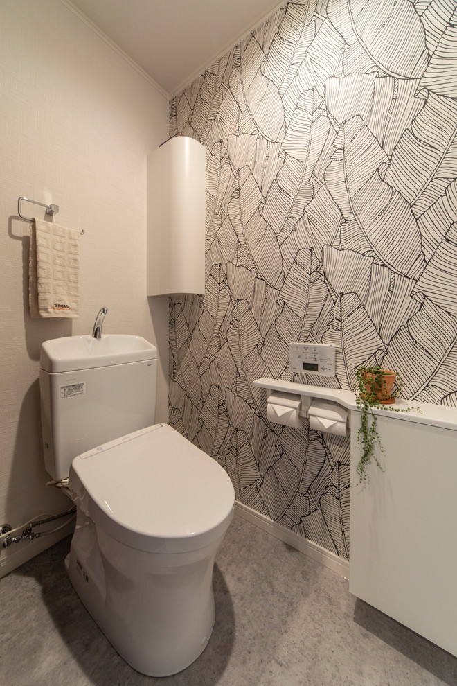 Inspiration pour un WC et toilettes minimaliste avec un placard à porte plane, des portes de placard blanches, un mur blanc et un sol gris.