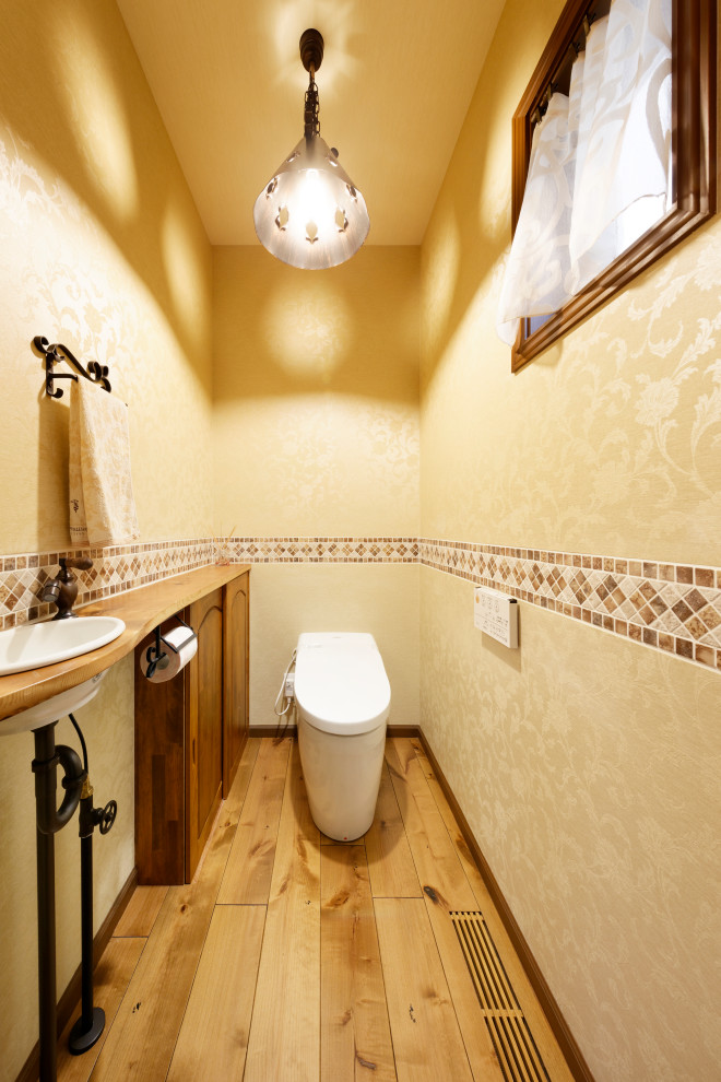 Idées déco pour un WC et toilettes montagne avec WC séparés, un carrelage marron, mosaïque, un mur beige, un sol en bois brun, un plan de toilette en bois, un sol marron, un plan de toilette marron, meuble-lavabo encastré, un plafond en papier peint et du papier peint.