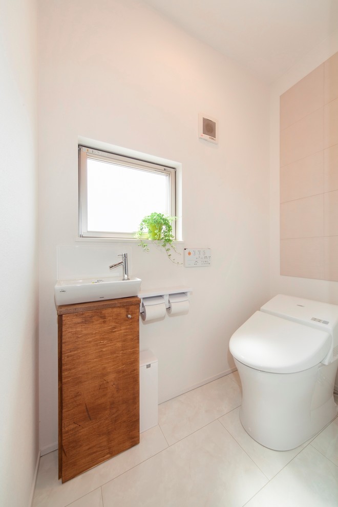 Réalisation d'un WC et toilettes minimaliste avec un mur blanc et un sol blanc.
