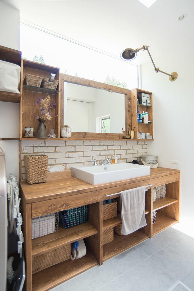 Idée de décoration pour un WC et toilettes asiatique en bois vieilli de taille moyenne avec un mur blanc, un sol en carrelage de porcelaine, un sol gris, un placard sans porte et une vasque.