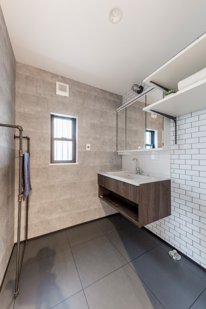 На фото: туалет в стиле лофт с серыми стенами, монолитной раковиной и серым полом с