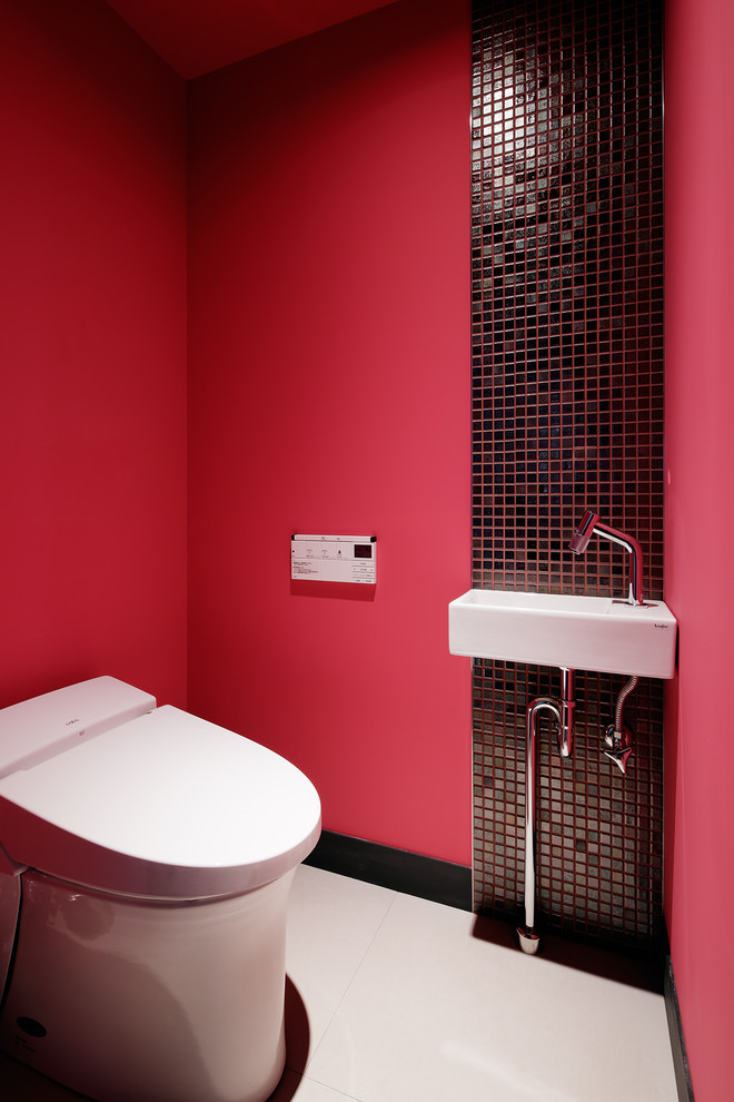 Пример оригинального дизайна: туалет в стиле модернизм с красными стенами, консольной раковиной, коричневой плиткой, плиткой мозаикой, полом из керамогранита, бежевым полом, белой столешницей и унитазом-моноблоком