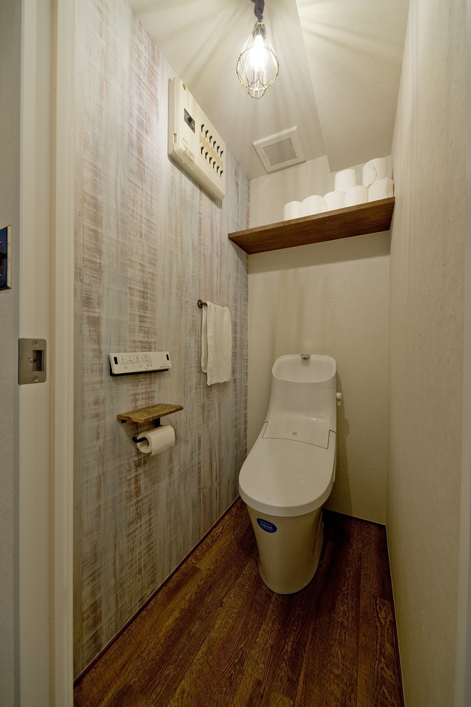 Пример оригинального дизайна: туалет в стиле ретро с унитазом-моноблоком, паркетным полом среднего тона и коричневым полом