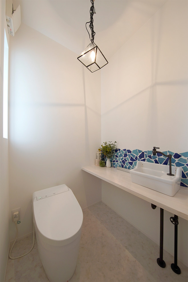 他の地域にあるモダンスタイルのおしゃれなトイレ・洗面所 (白い壁、ベッセル式洗面器、白い床) の写真