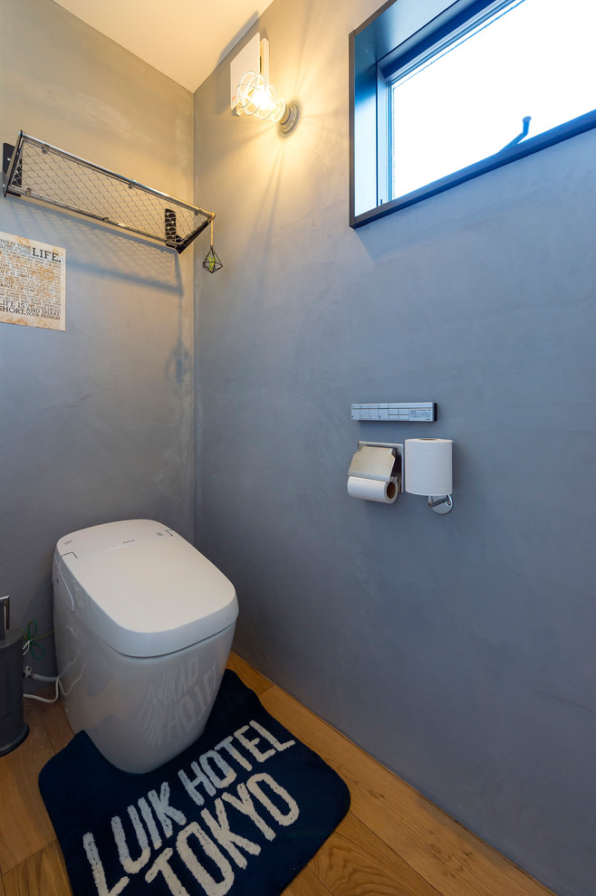 他の地域にあるインダストリアルスタイルのおしゃれなトイレ・洗面所 (グレーの壁、無垢フローリング、茶色い床) の写真