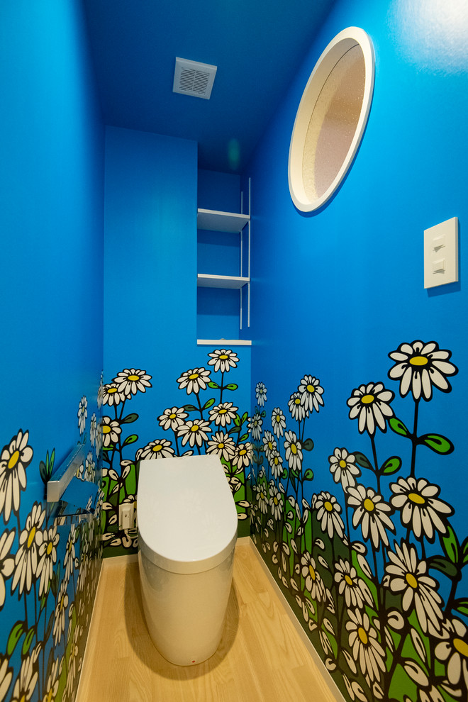 Powder room - scandinavian light wood floor and beige floor powder room idea in Fukuoka with blue walls