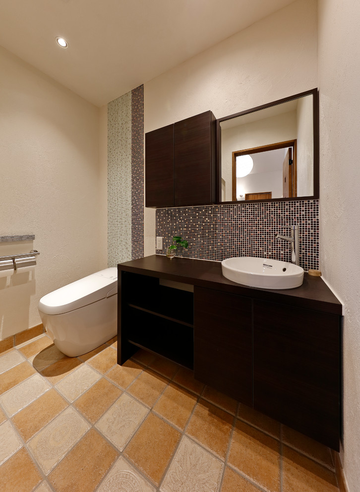 他の地域にあるモダンスタイルのおしゃれなトイレ・洗面所 (白い壁、ベッセル式洗面器、マルチカラーの床) の写真