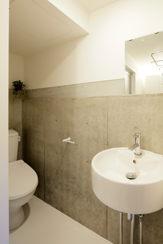 東京23区にあるモダンスタイルのおしゃれなトイレ・洗面所 (一体型トイレ	、グレーのタイル、クッションフロア、壁付け型シンク、白い床) の写真