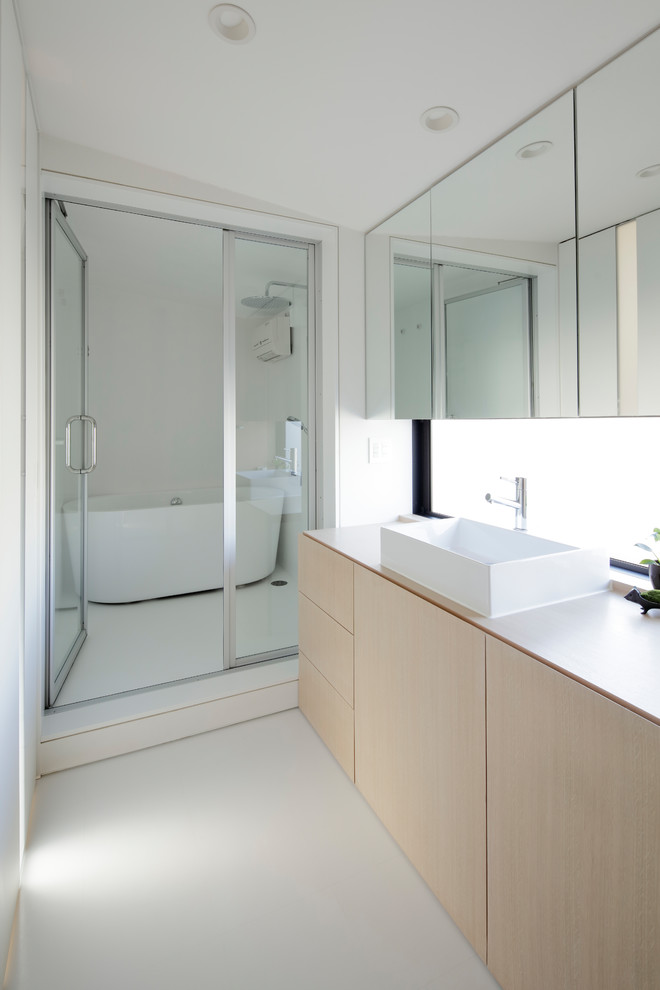 Inspiration pour un WC et toilettes minimaliste en bois clair avec WC séparés, un mur blanc, un sol en vinyl, une vasque, un plan de toilette en bois, un sol blanc, un plan de toilette blanc et un placard à porte affleurante.