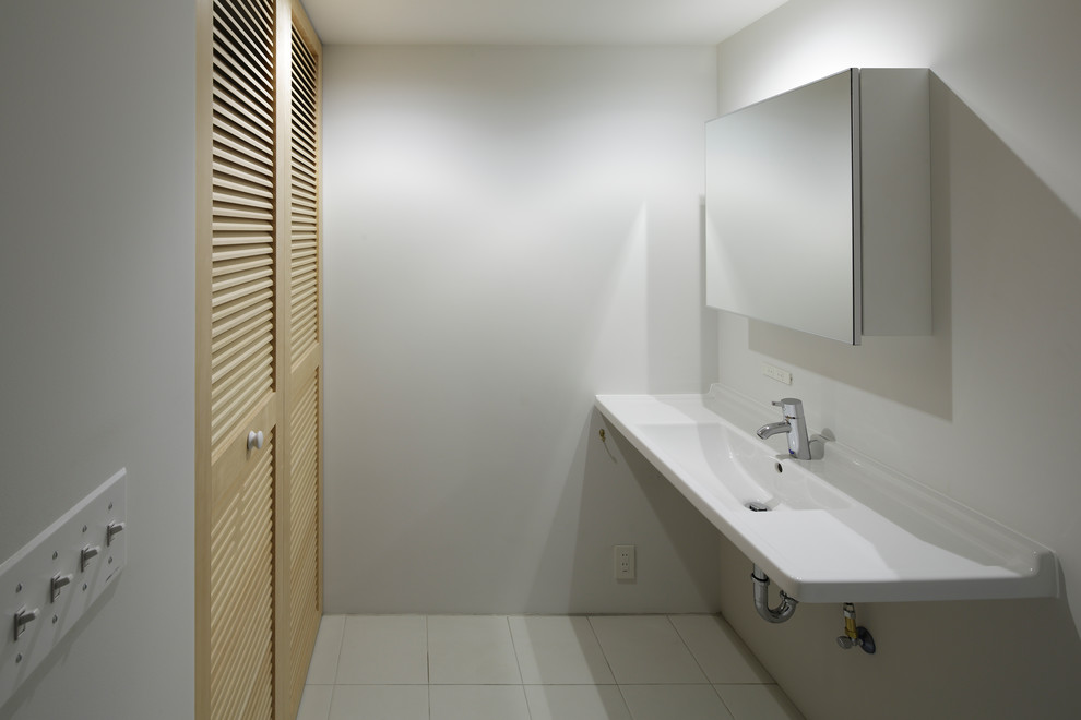 東京23区にあるコンテンポラリースタイルのおしゃれなトイレ・洗面所 (磁器タイルの床、コンソール型シンク、白い床) の写真