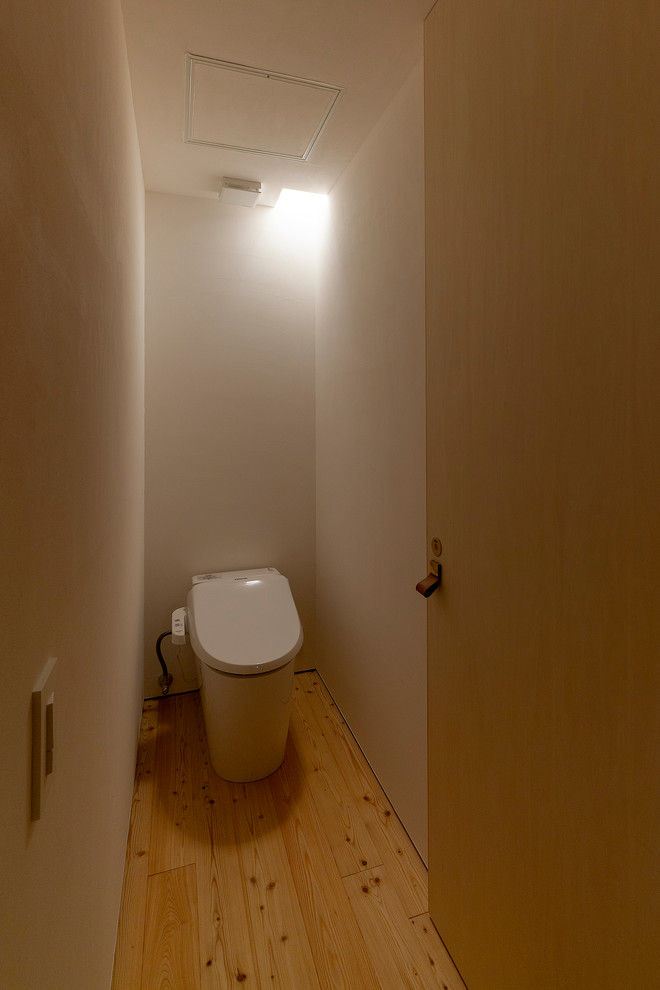 Kleine Moderne Gästetoilette mit Bidet, weißer Wandfarbe, hellem Holzboden und beigem Boden in Osaka