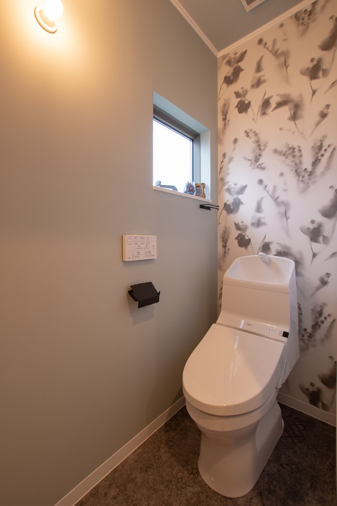 Immagine di un piccolo bagno di servizio minimalista con pareti multicolore, pavimento grigio, WC monopezzo e pavimento in vinile