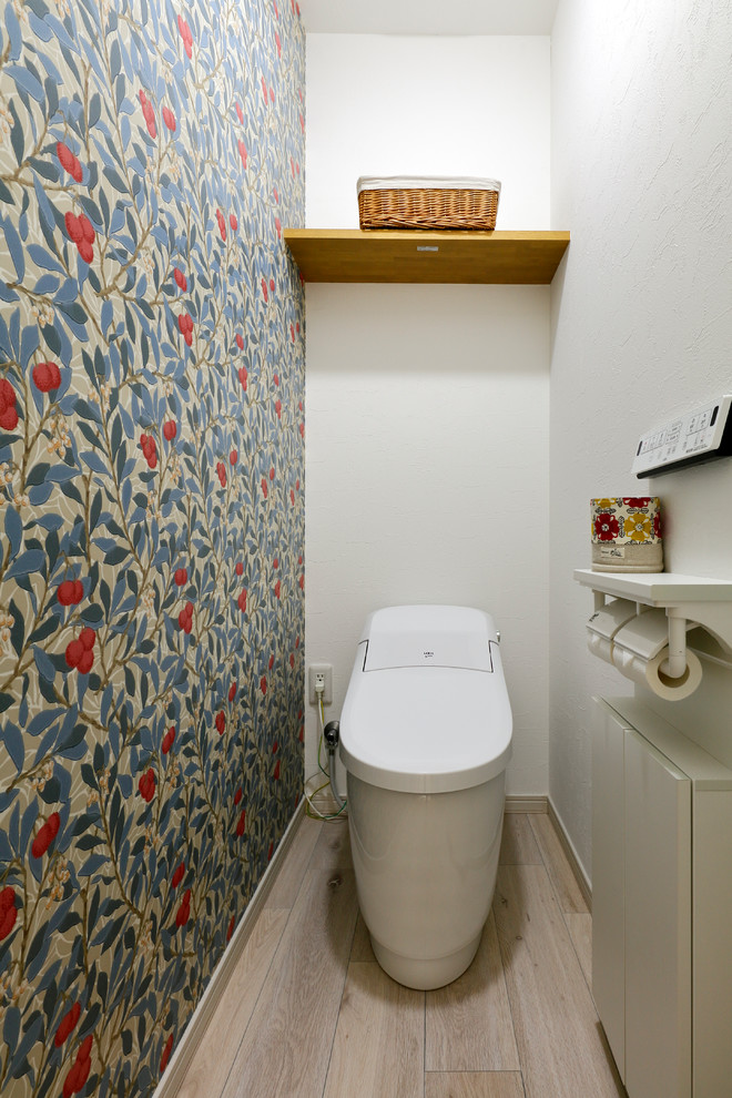 На фото: туалет в скандинавском стиле с разноцветными стенами, деревянным полом и белым полом с
