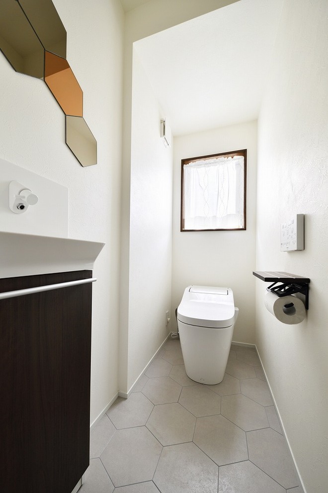 東京23区にあるコンテンポラリースタイルのおしゃれなトイレ・洗面所 (フラットパネル扉のキャビネット、黒いキャビネット、白い壁、グレーの床、壁付け型シンク) の写真