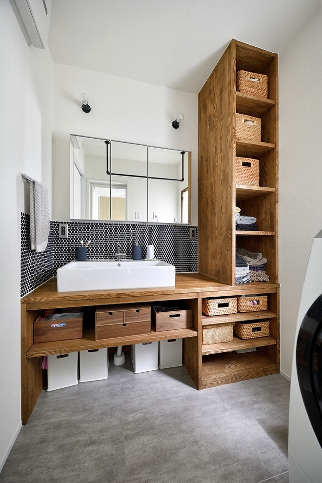 Moderne Gästetoilette mit offenen Schränken, weißer Wandfarbe, Betonboden, Aufsatzwaschbecken, Waschtisch aus Holz, grauem Boden und brauner Waschtischplatte in Tokio