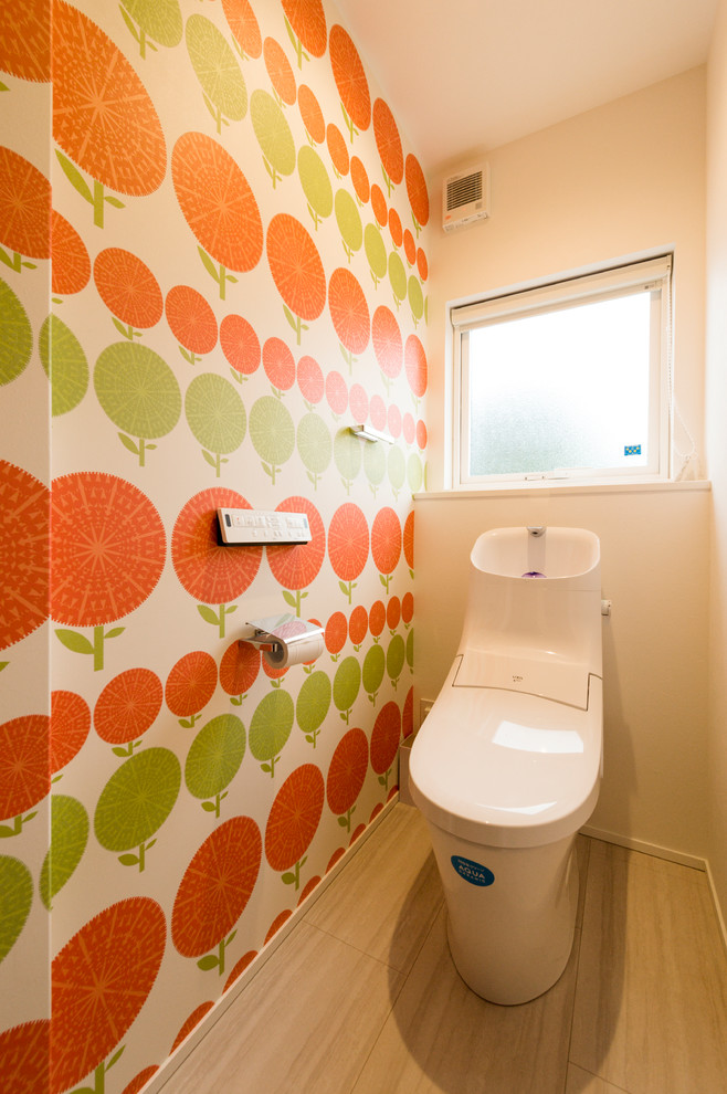 Bild på ett funkis toalett, med flerfärgade väggar, målat trägolv och beiget golv