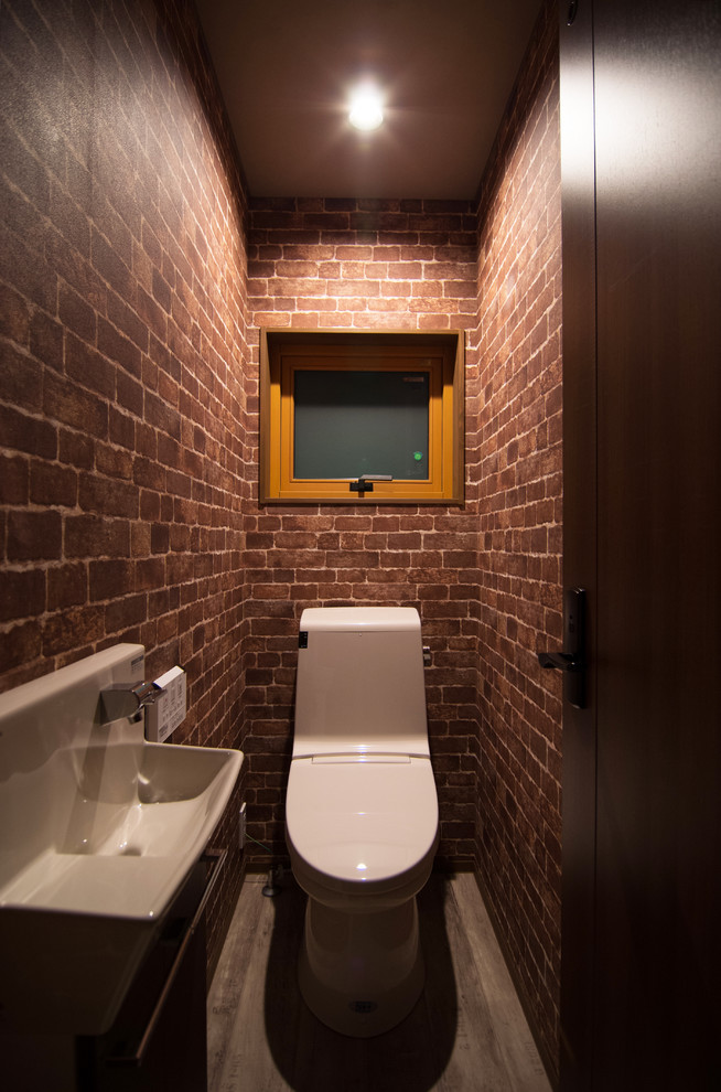 Idee per un bagno di servizio etnico con pareti marroni, pavimento grigio, WC monopezzo e lavabo sospeso