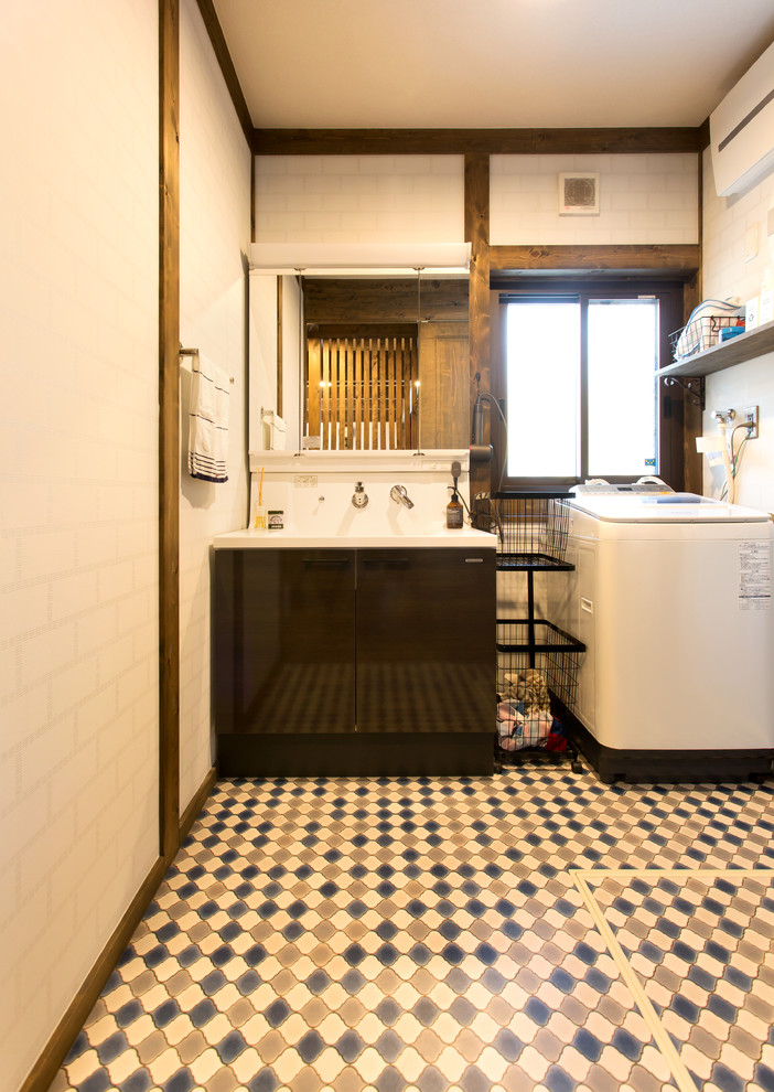 名古屋にあるアジアンスタイルのおしゃれなトイレ・洗面所 (フラットパネル扉のキャビネット、黒いキャビネット、白い壁、一体型シンク、マルチカラーの床) の写真