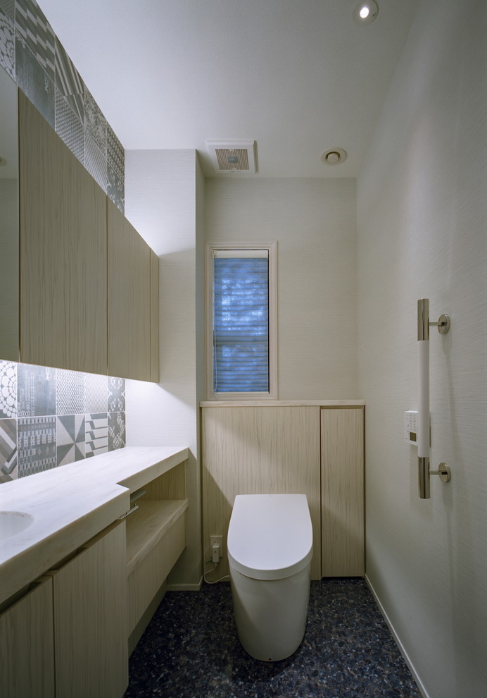 Inspiration for a scandi cloakroom in Kobe with beaded cabinets, beige cabinets, a one-piece toilet, black and white tiles, white walls, vinyl flooring, a submerged sink, solid surface worktops, blue floors and beige worktops.