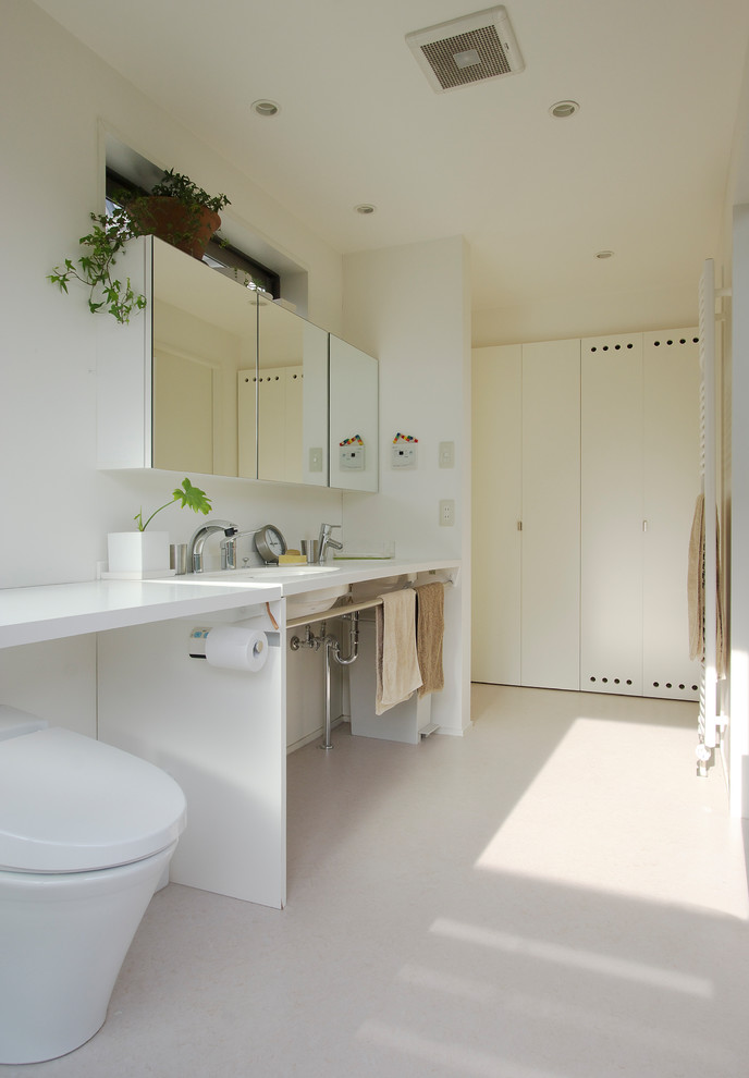他の地域にあるモダンスタイルのおしゃれなトイレ・洗面所 (オープンシェルフ、白い壁、一体型シンク、ベージュの床、白い洗面カウンター) の写真