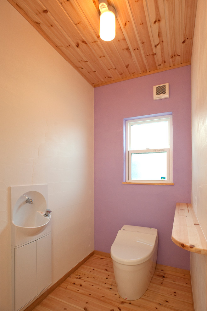 他の地域にあるカントリー風のおしゃれなトイレ・洗面所 (一体型トイレ	、紫の壁、無垢フローリング、壁付け型シンク、木製洗面台) の写真