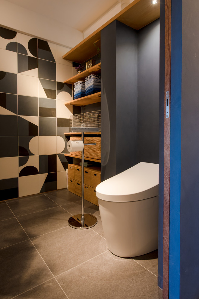 Идея дизайна: туалет в восточном стиле с унитазом-моноблоком, бежевой плиткой, серой плиткой, белой плиткой, цементной плиткой, черными стенами и коричневым полом