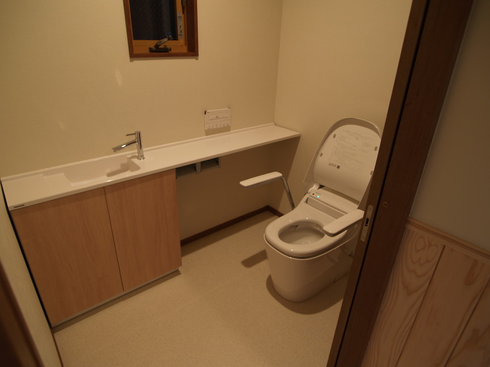 Esempio di un grande bagno di servizio etnico con ante in legno chiaro, WC monopezzo, pareti beige, top in superficie solida e top bianco